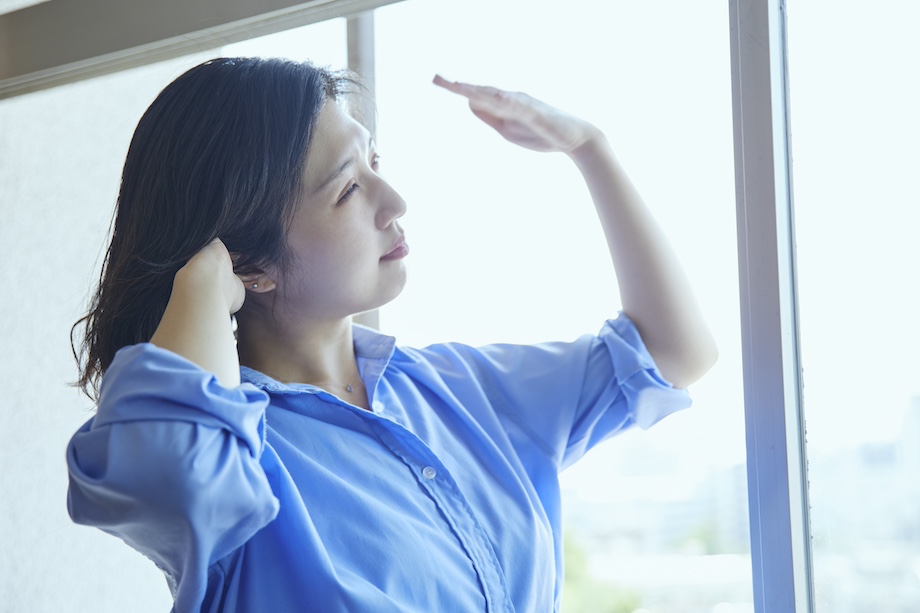 暑そうに風を仰ぐ女性