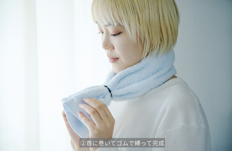 タオルマフラーを首に巻く女性
